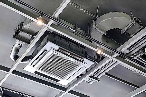 graue Zimmerdecke mit Lüftungskanälen und einem großen Auslass