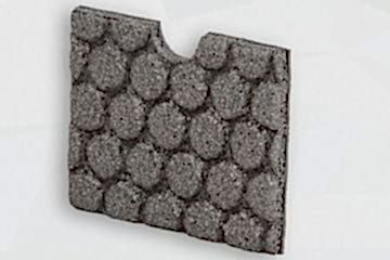 Graue Schaumstoffplatte mit Noppenmuster stehend vor grauem Hintergrund